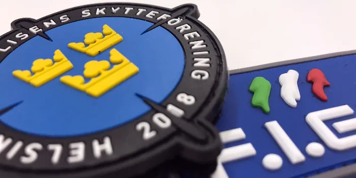 Närbild på färgglada PVC och gummimärken med logotyper och text i utstickande 3D-Relief.