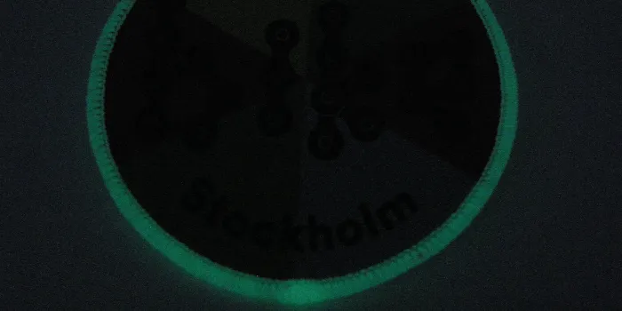 Vävt tygmärke med fluorescerande langetterad kant skapad i tråd som lyser i mörkret.