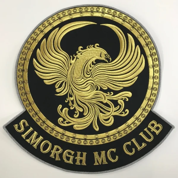 MC-märke med club-logo föreställande fågeln Fenix broderad i gyllene brodyrtråd.