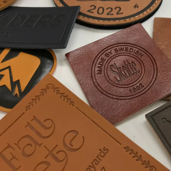 En samling olika skinn och lädermärken, både äkta och fake, med olika märkningstekniker såsom tryck, emboss och deboss.